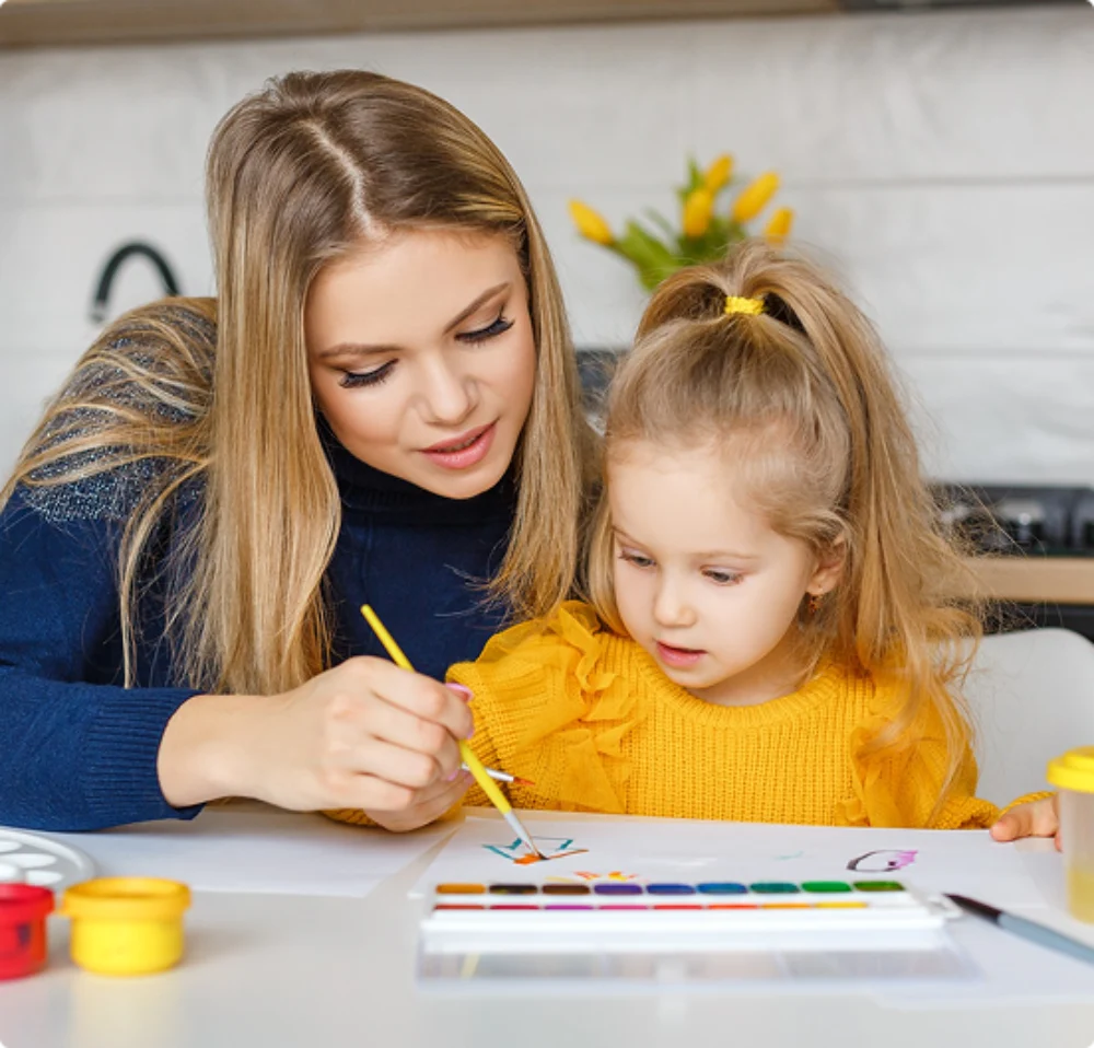 De werving en selectie van een nanny: Nanny met kind aan het verven